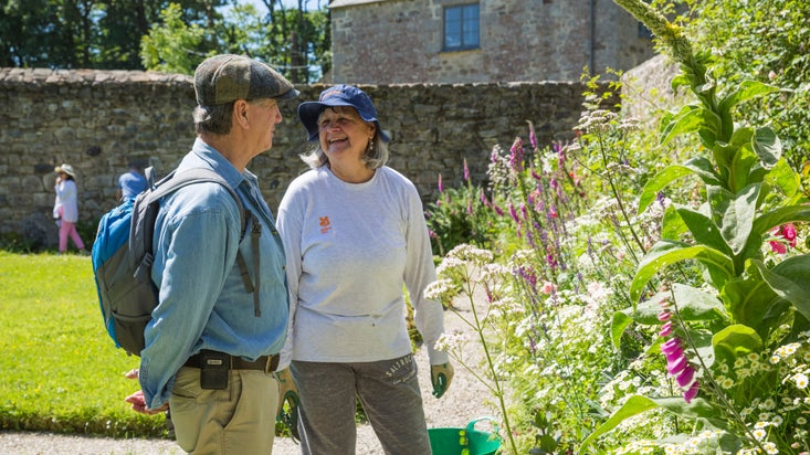 Volunteer with visitors in the garden at Godolphin, Cornwall